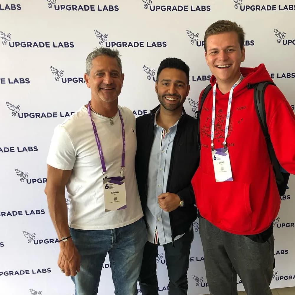 Steven with two founders in front of an Upgrade Labs backdrop